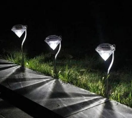 White solar-powered garden spotlight with adjustable head on a metal stake for outdoor use.