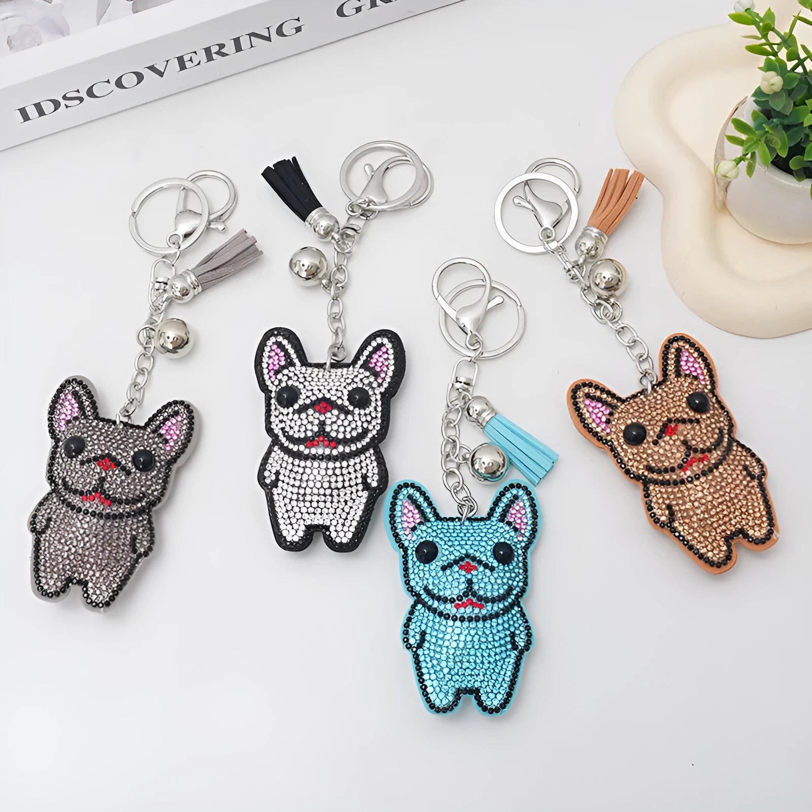 Close-up of a rhinestone and alloy French dog cartoon keychain with tassel pendant