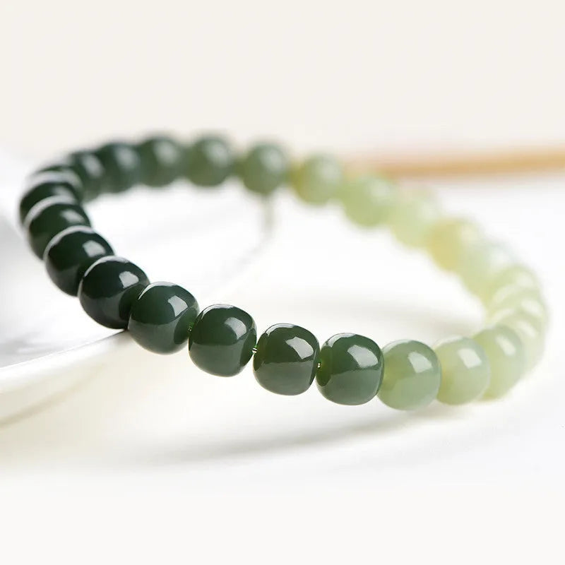 Natural Hetian jade bracelet showing a clear water gradient colour on polished beads.
