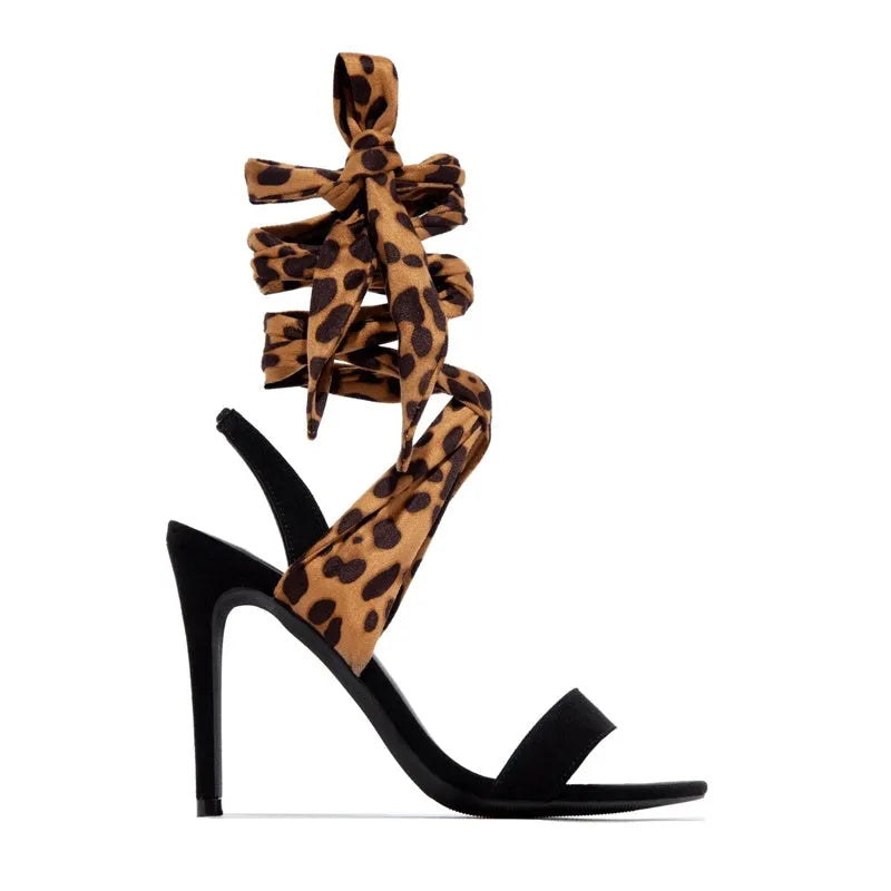 Light brown leopard print women's high-heel sandals with cross straps and a thin stiletto heel.