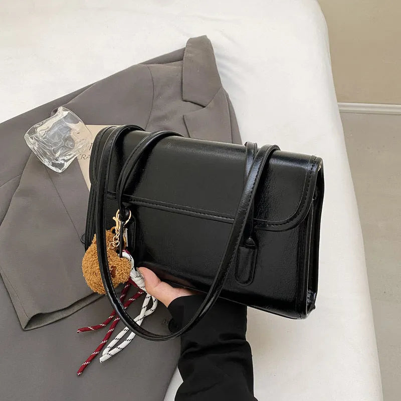 Women's brown PU Maillard shoulder bag with pendant detail, showing horizontal square shape and double straps.