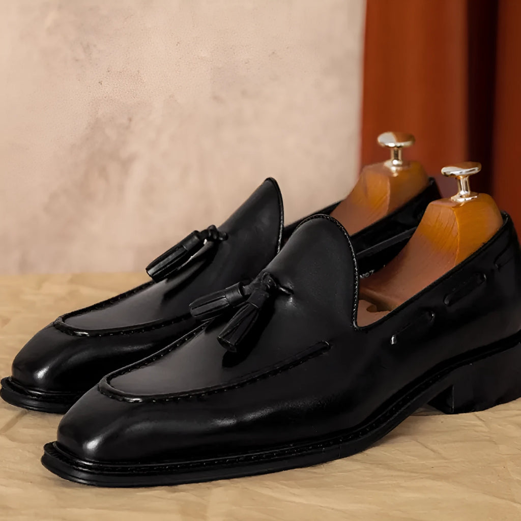Men's black genuine leather slip-on loafers with fringed detailing and rubber sole