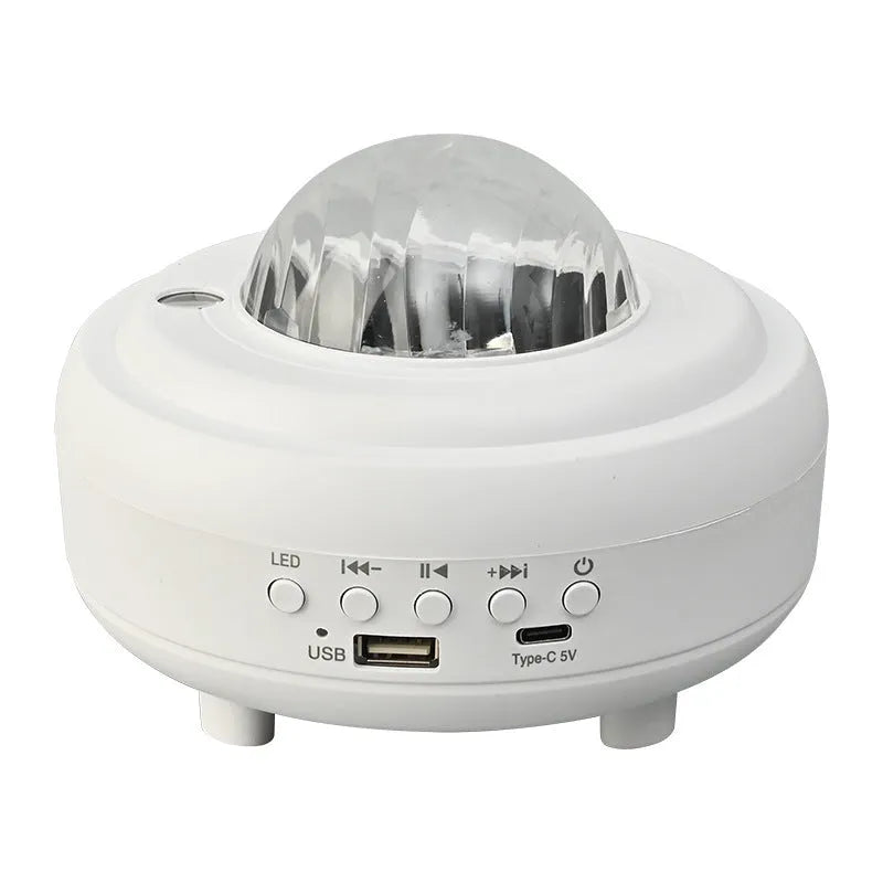 White Galaxy Star Projector night light with Bluetooth speaker on a table