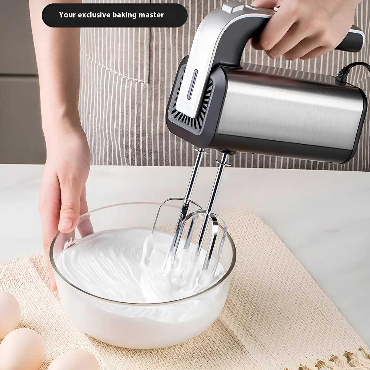 Silver handheld electric whisk with five-speed control dial and mixing attachments