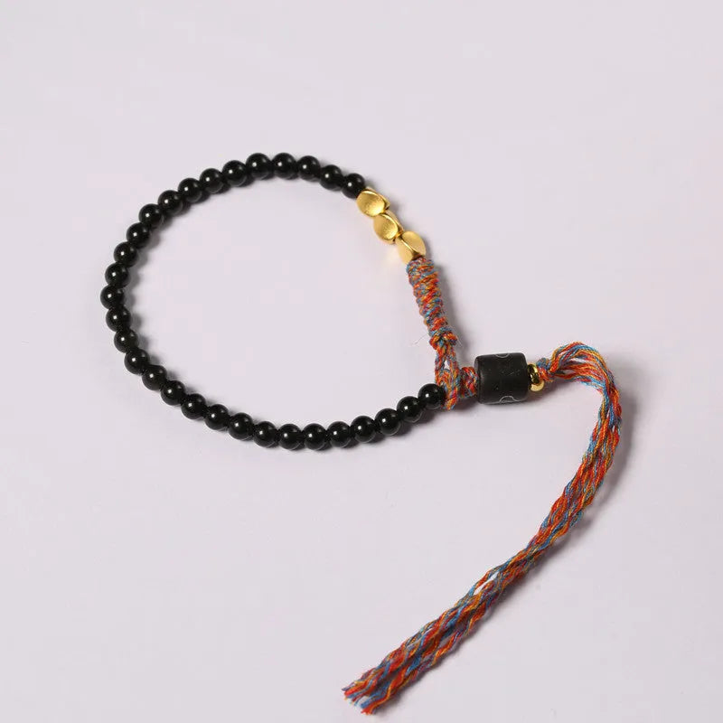 Hand-woven obsidian wrist bracelet showing 4mm width and textured strand construction