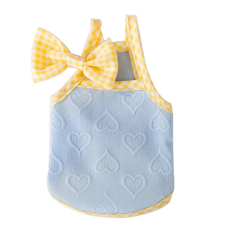 Small dog wearing a blue elastic vest with a heart texture pattern and bow suspenders.