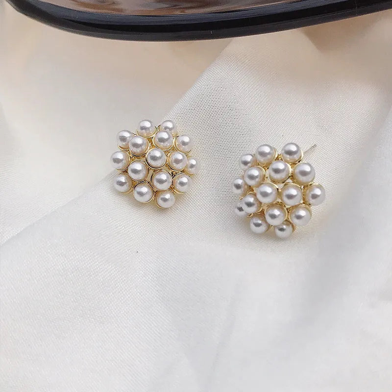 Gold colour Korean-style drop earrings featuring a pineapple and starfish design with pearl and gemstone inlay.