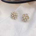 Gold colour Korean-style drop earrings featuring a pineapple and starfish design with pearl and gemstone inlay.