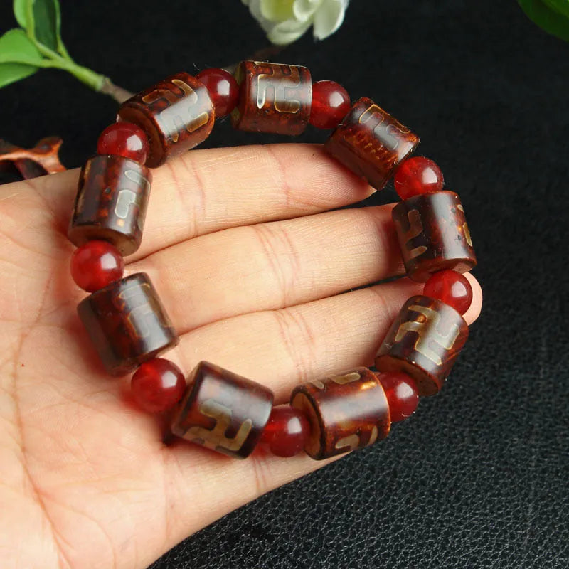 Distressed agate Tibetan bead bracelet with three-eye motifs and polished finish.