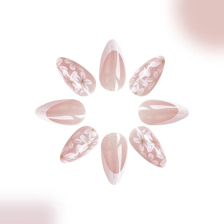Short almond artificial nail tips with French manicure and glitter flower design in C625 colour