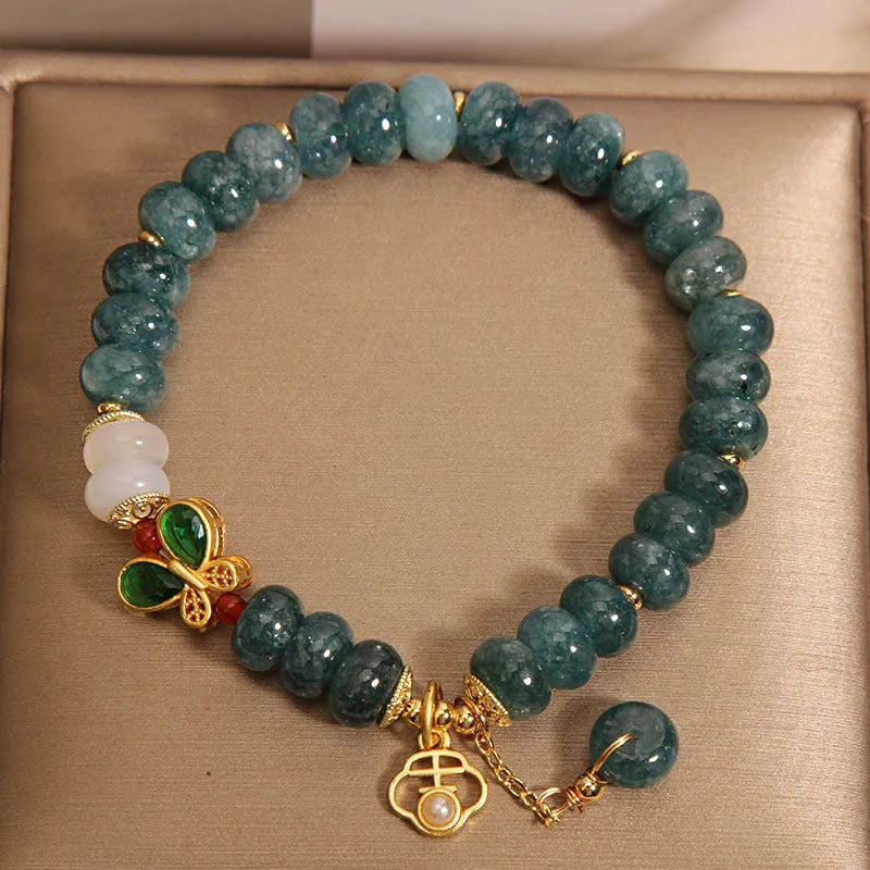 Blue water jade and white agate abacus bead crystal bracelet with rhinestone details and butterfly motif on alloy base