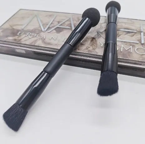 Double-headed makeup brush with black sponge end and pointed brush end on wooden handle