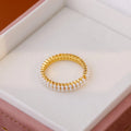 Gold geometric ring with open mouth design and pearl elements on female hand