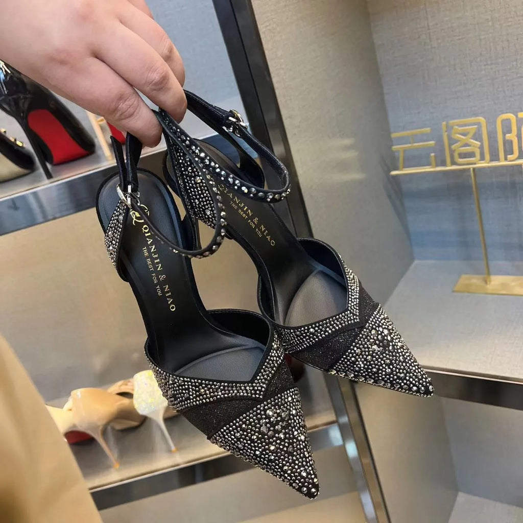 Women's black stiletto heels with pointed toe, hollowed design and red sole