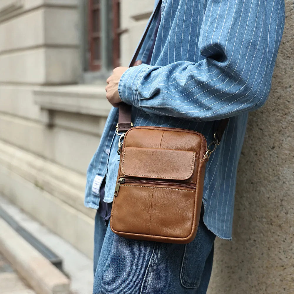 Men's brown genuine leather crossbody shoulder bag with visible stitching and a solid colour design.