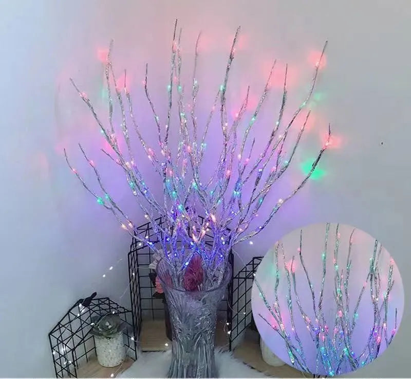 LED decorative tree light with silver branches in a vase, emitting coloured light.
