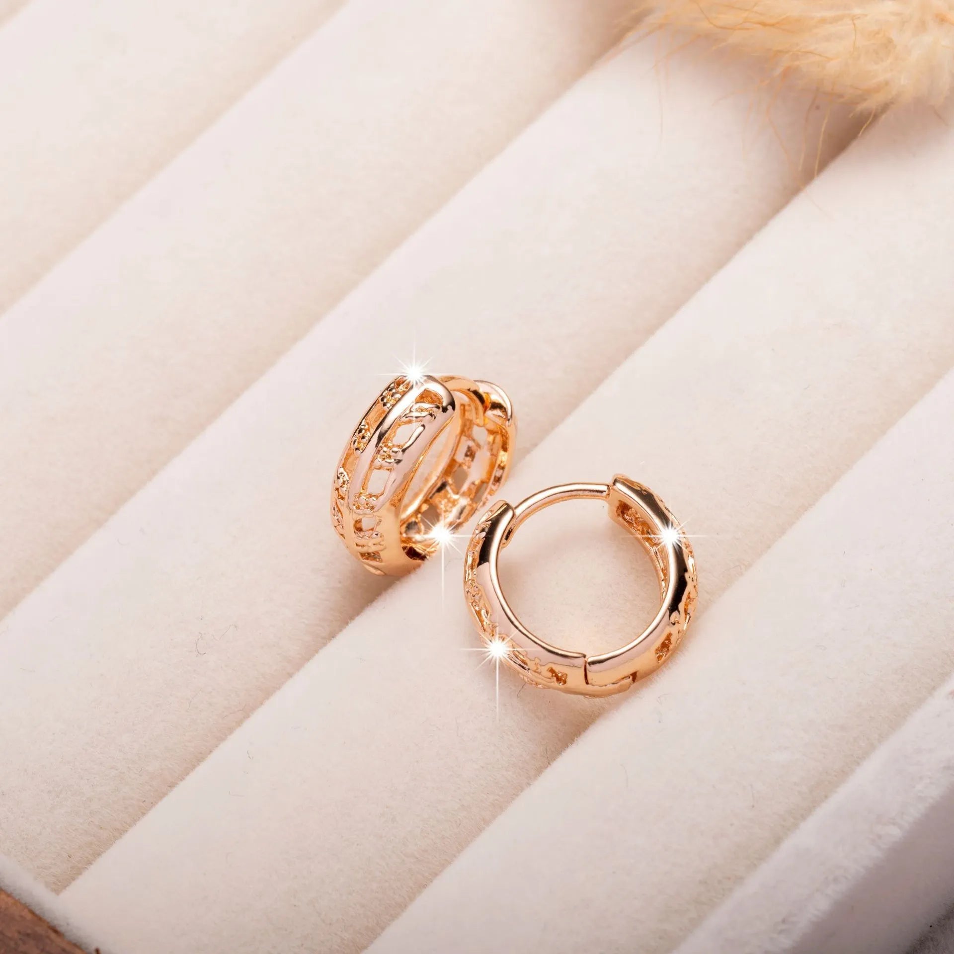 Rose gold copper earrings with hollowed-out heart and leaf designs on white background