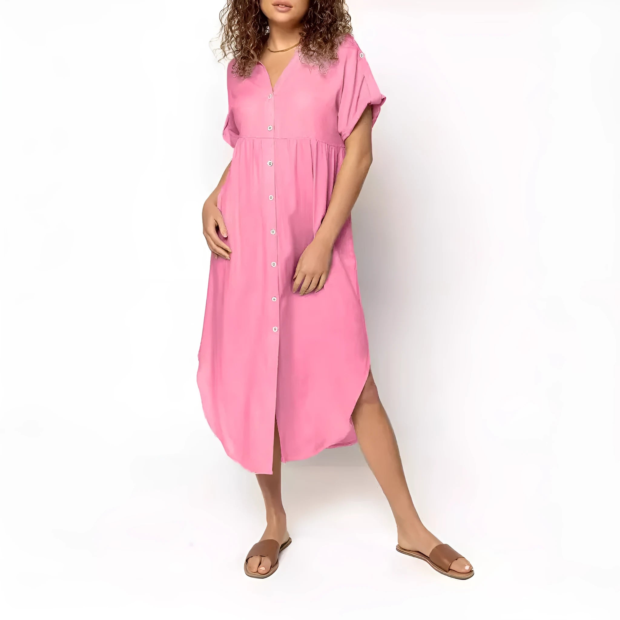 A woman wearing a loose-fitting, mid-length apricot-coloured casual dress with a button-down front.