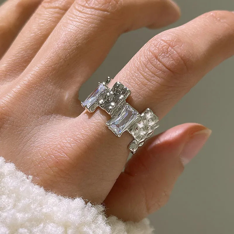 Open geometric zircon ring with three-dimensional decoration in silver colour