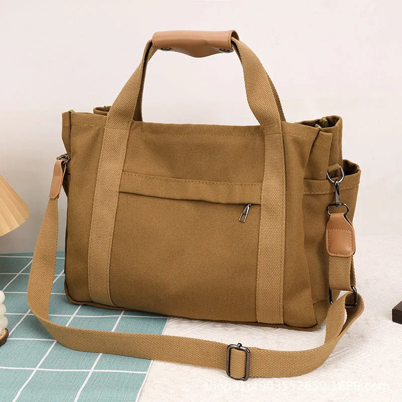 Large horizontal square canvas tote bag in army green with visible sewing lines and open zipper sides.