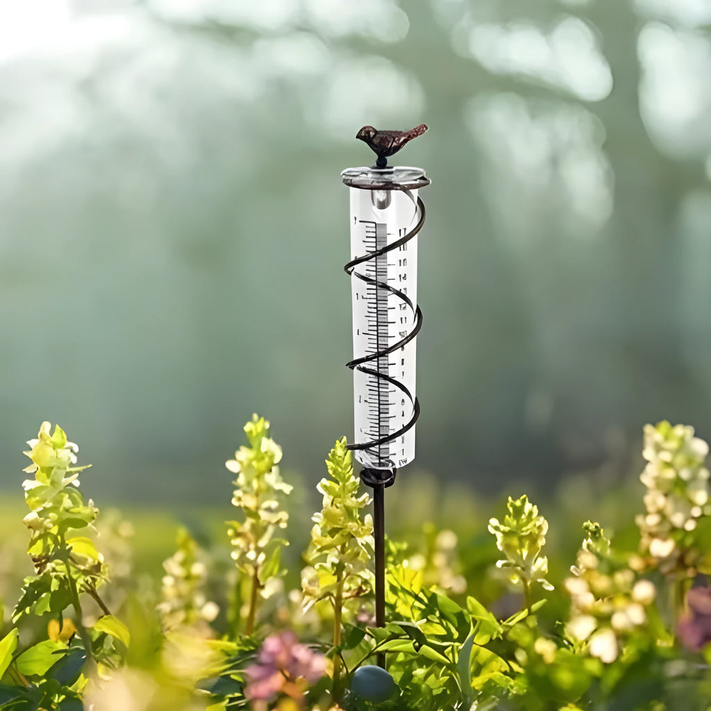 Cast iron hummingbird garden rain gauge with glass measurement tube showing 1-20 scale