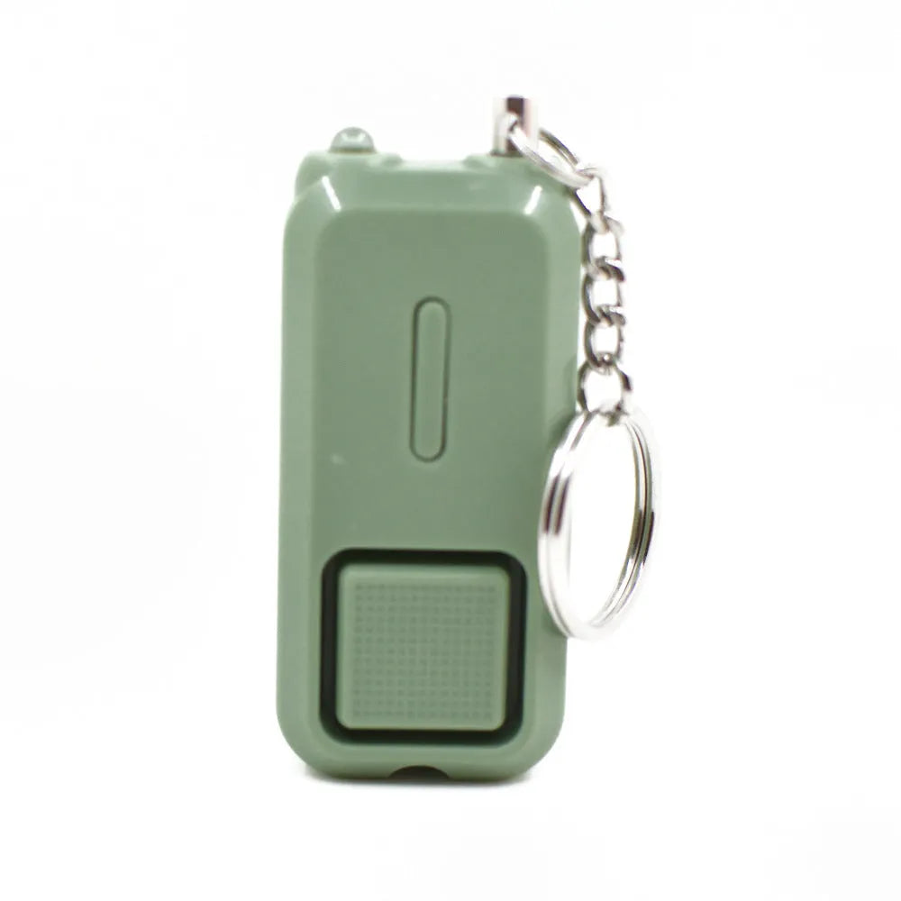 Small pink personal safety alarm on a keyring with a white box.
