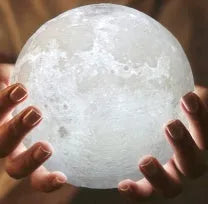 3D printed white moon lamp with detailed craters on a wooden stand, showing touch ring at base.