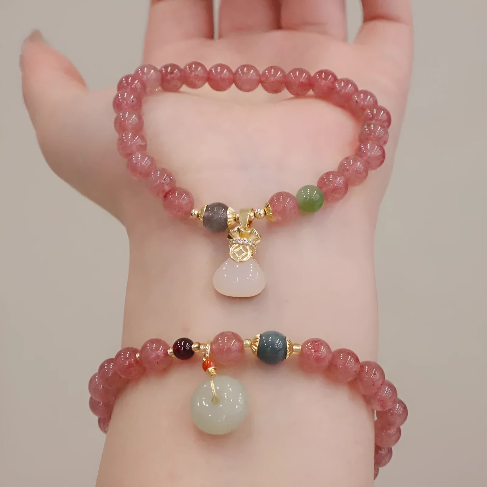Women's geometric strawberry quartz bracelet with Chinese purse charm and safety buckle clasp.
