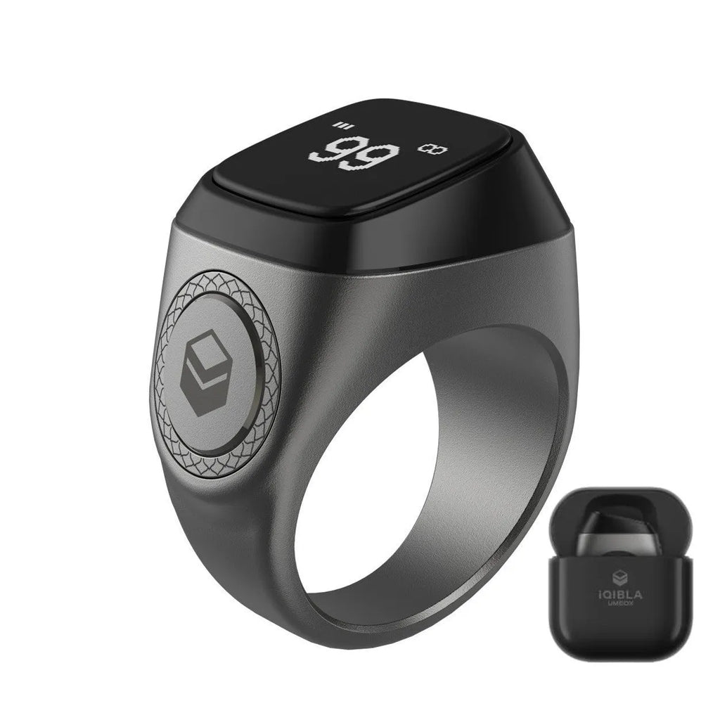 Zikr1 smart ring in silver showing OLED display with Tasbih count, next to charging case.