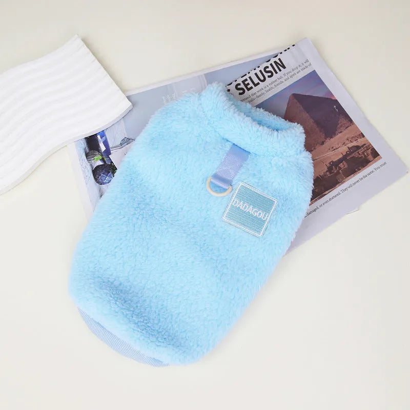 Fluffy blue coral fleece pet jacket with multi-coloured pull ring fastening on a dog model.
