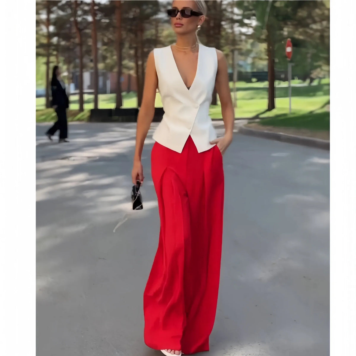 Women's beige two-piece set with deep V-neck sleeveless top and high-waist wide-leg trousers.