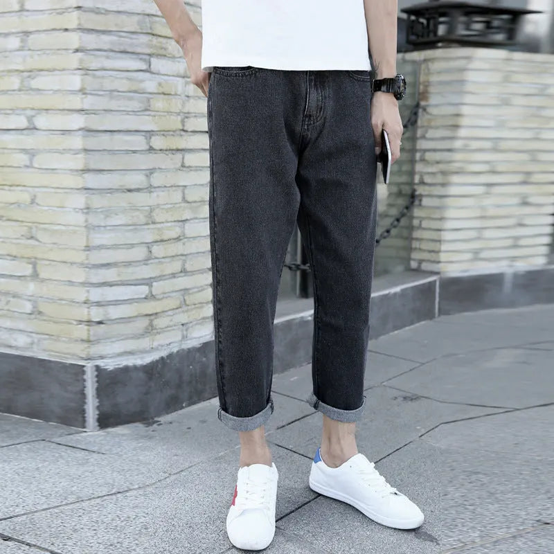Man wearing loose straight leg cotton jeans in blue, showcasing the light straight open leg style.