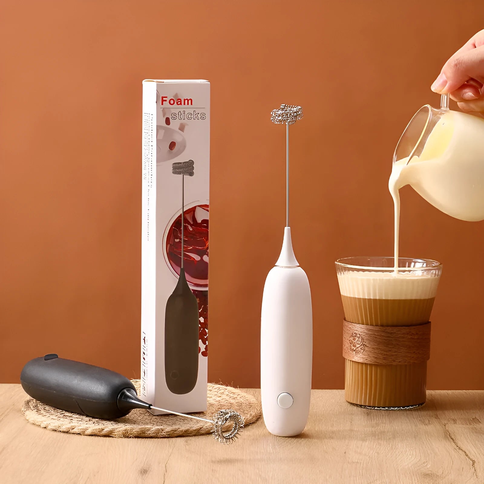 Hand-held electric milk frother blender in black or white colour for coffee preparation