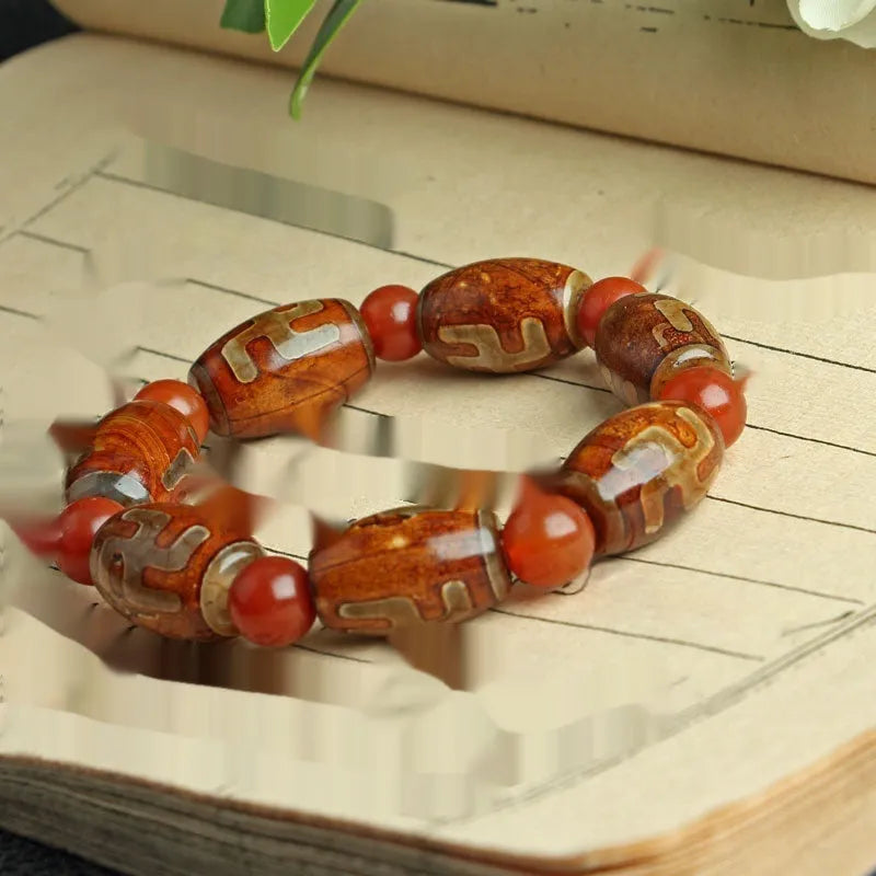 Distressed agate Tibetan bead bracelet with three-eye motifs and polished finish.