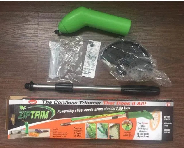 Cordless handheld lawn trimmer with extension pole and protective debris shield on a lawn.