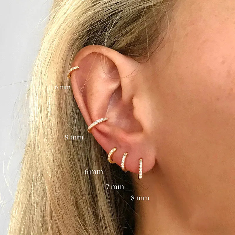 Geometric circle zircon stud earrings in gold, rose gold, or silver colour on a plain background.