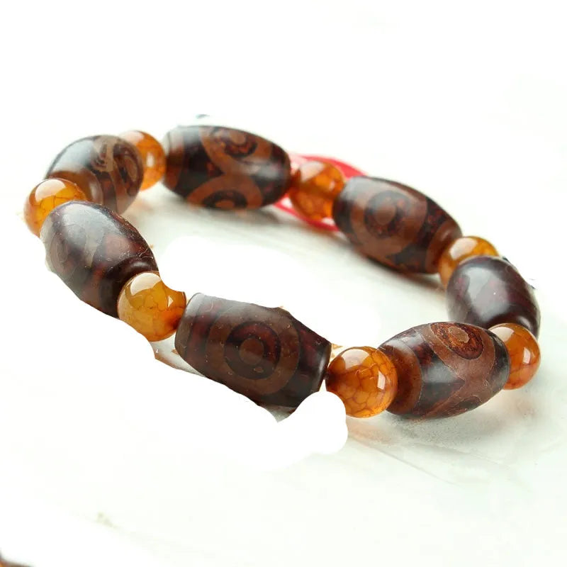 Distressed agate Tibetan bead bracelet with three-eye motifs and polished finish.