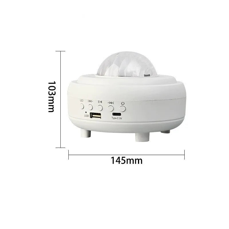 White Galaxy Star Projector night light with Bluetooth speaker on a table
