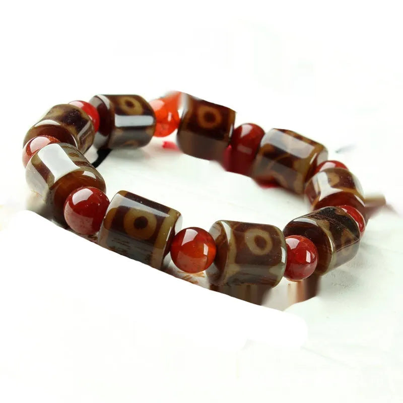 Distressed agate Tibetan bead bracelet with three-eye motifs and polished finish.