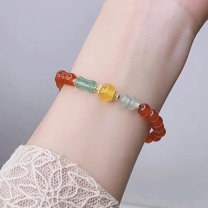 Women's red agate bracelet with manual Chinese dragon and lucky bag designs.