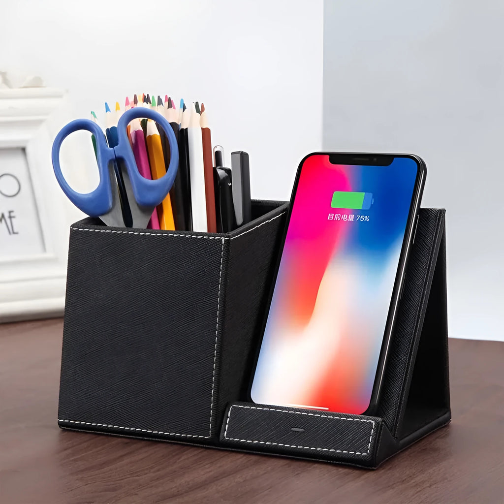 Black leather pen holder with integrated wireless phone charging pad on a desk.
