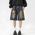 Retro blue loose-fit distressed denim jeans on a hanger, showing ripped detailing.