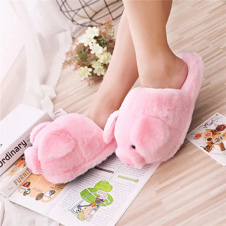 Pink plush floor slippers with a cute pig design on the upper, shown from a side view.