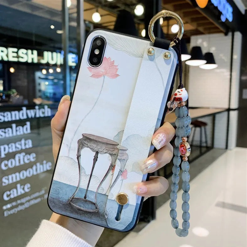 Rose flower design wrist strap case for Apple iPhone on a table.