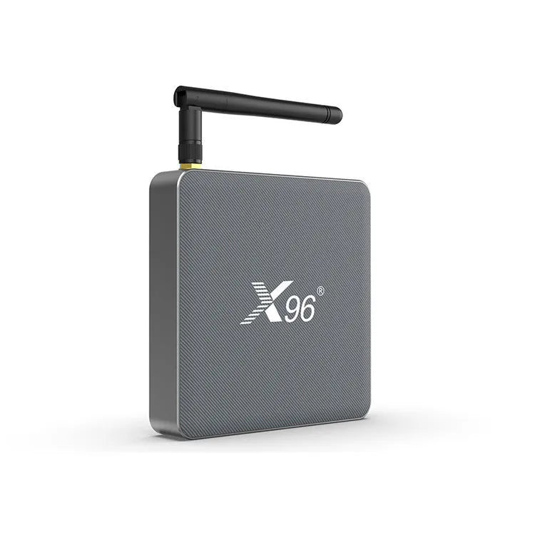 Android smart TV set-top box with voice control remote on a table next to a television.