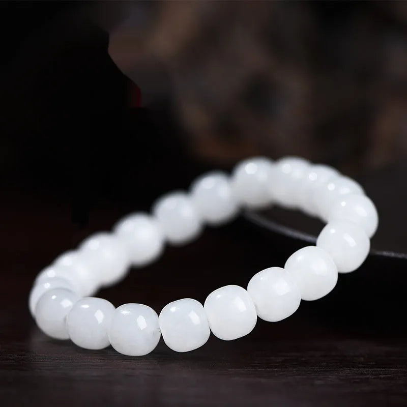 White Hetian jade barrel bead bracelet on a wrist, showing unisex casual style