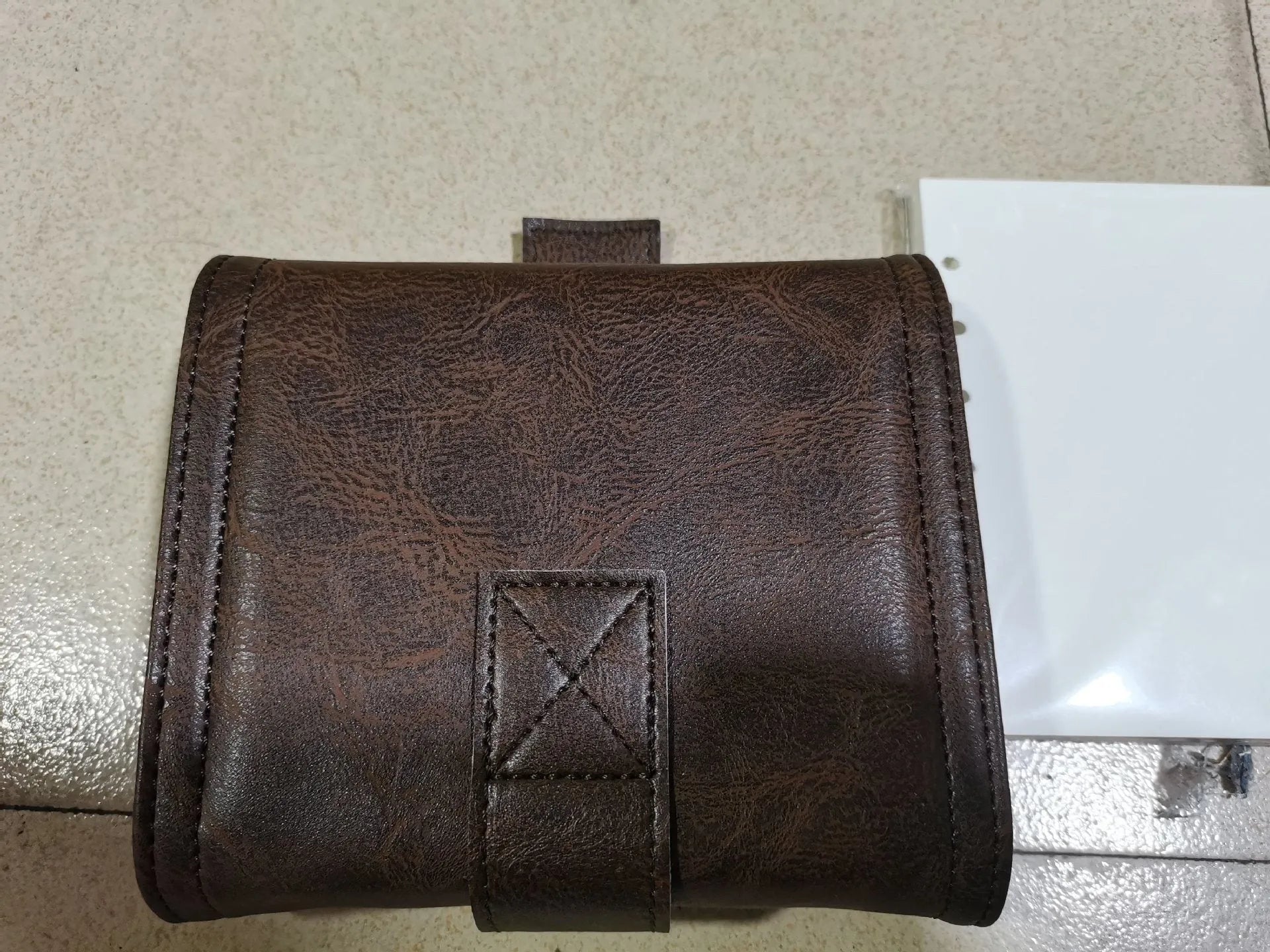 Brown retro leather-style A7 notebook with a buckle closure, shown open to reveal loose-leaf binder binding.
