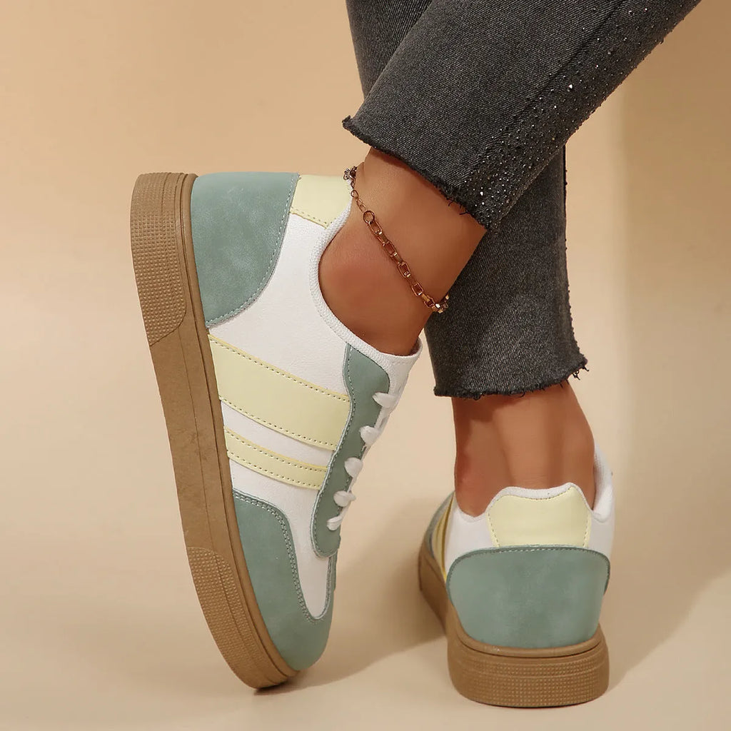 Green women's retro sports pumps with cross straps, a round toe, and a flat rubber sole.