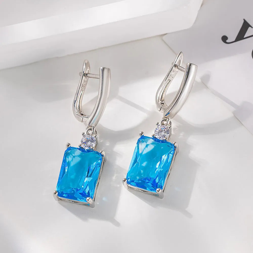 A pair of square, geometric earrings with a gold electroplated finish on a copper base.