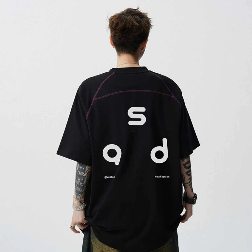 Man wearing a loose fit black cotton t-shirt with a letter print on the chest.